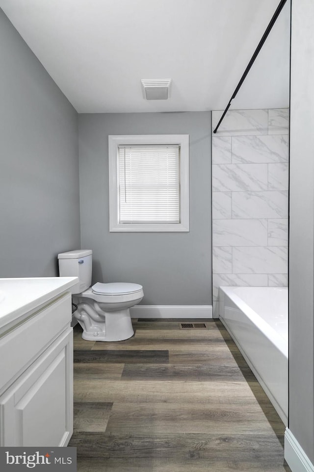 full bathroom with vanity, toilet, wood-type flooring, and shower / tub combination