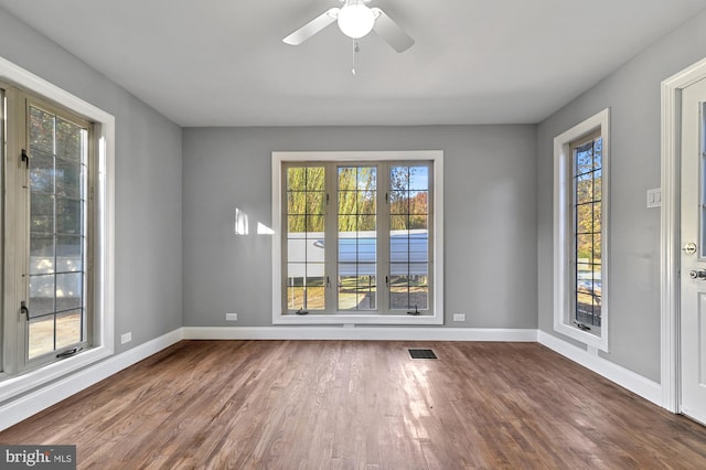 unfurnished room with a healthy amount of sunlight and hardwood / wood-style flooring