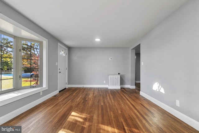 unfurnished room with dark wood-type flooring