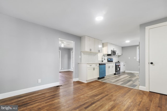 kitchen with ceiling fan, appliances with stainless steel finishes, dark hardwood / wood-style flooring, white cabinetry, and sink