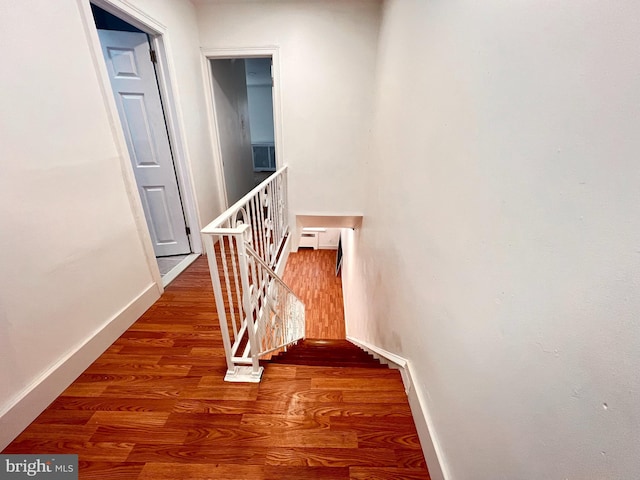 hallway with wood-type flooring and baseboard heating