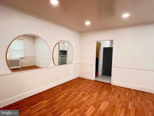 empty room featuring hardwood / wood-style floors and ornamental molding