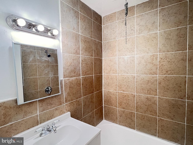 bathroom with vanity and tiled shower / bath