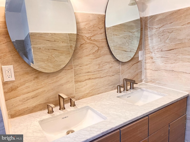 bathroom featuring backsplash, vanity, and tile walls