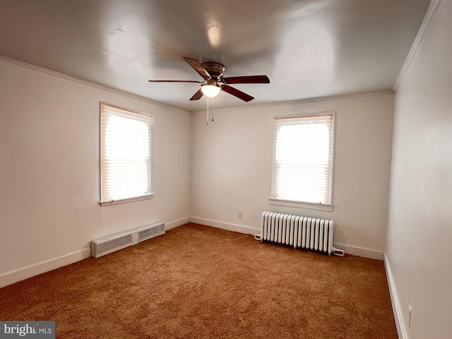 carpeted empty room with a wealth of natural light, ceiling fan, ornamental molding, and radiator