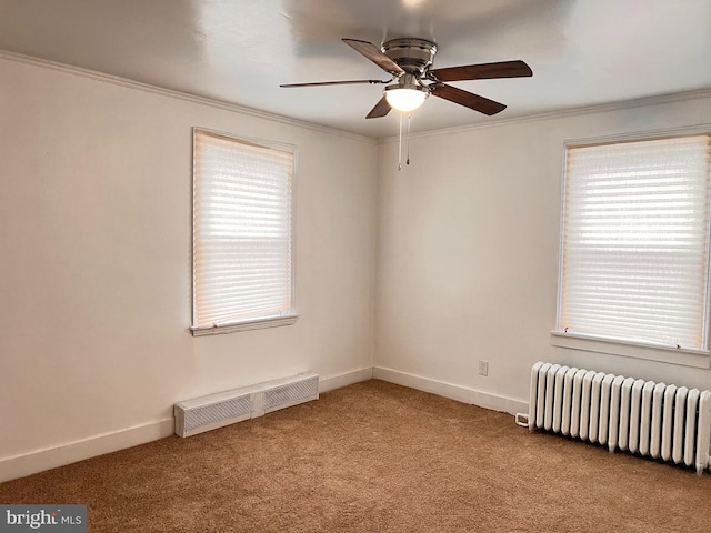 carpeted spare room with radiator heating unit, ceiling fan, and crown molding