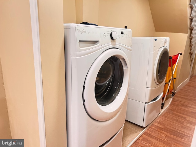 laundry room with separate washer and dryer and light hardwood / wood-style floors