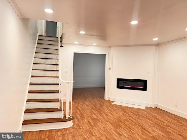 stairs featuring hardwood / wood-style flooring and ornamental molding