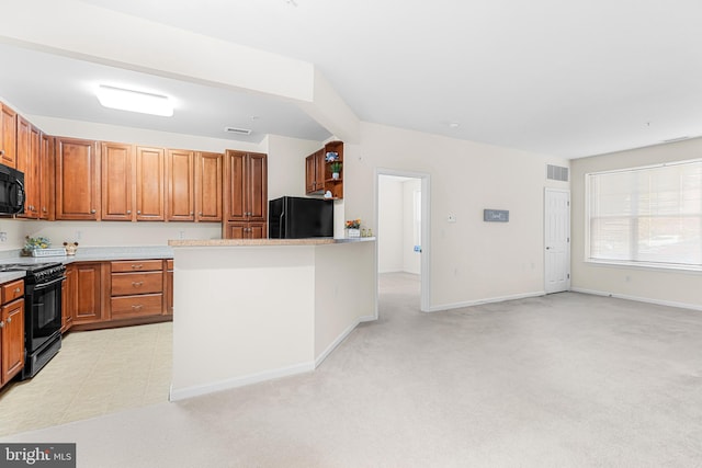 kitchen with black appliances and light carpet