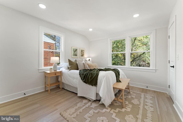 bedroom with light hardwood / wood-style floors and vaulted ceiling