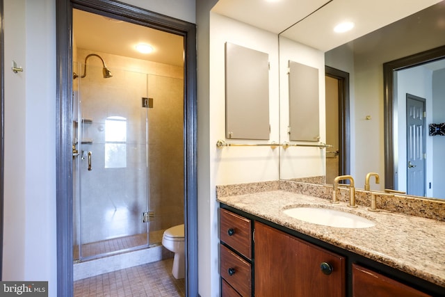 bathroom featuring toilet, an enclosed shower, vanity, and tile patterned floors