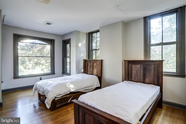 bedroom featuring multiple windows and wood-type flooring