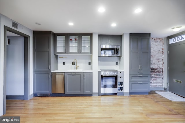 kitchen featuring gray cabinets, sink, appliances with stainless steel finishes, and light hardwood / wood-style floors