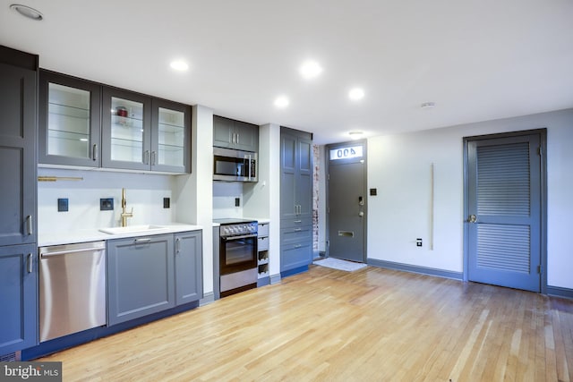 kitchen featuring stainless steel appliances, sink, and light wood-type flooring