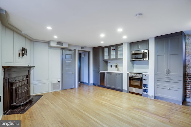 kitchen featuring light hardwood / wood-style floors, stainless steel appliances, and gray cabinetry