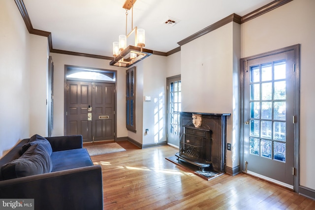 foyer featuring light hardwood / wood-style flooring, a chandelier, and crown molding