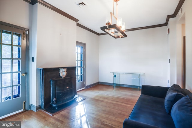 living room featuring ornamental molding, hardwood / wood-style flooring, and a healthy amount of sunlight