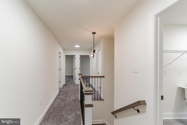 hall with dark colored carpet