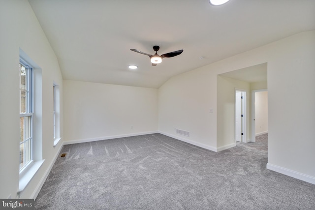 empty room with lofted ceiling, carpet floors, and ceiling fan