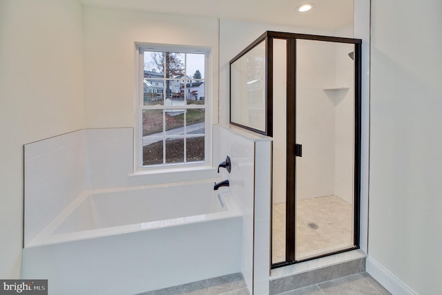 bathroom featuring tile patterned flooring and separate shower and tub