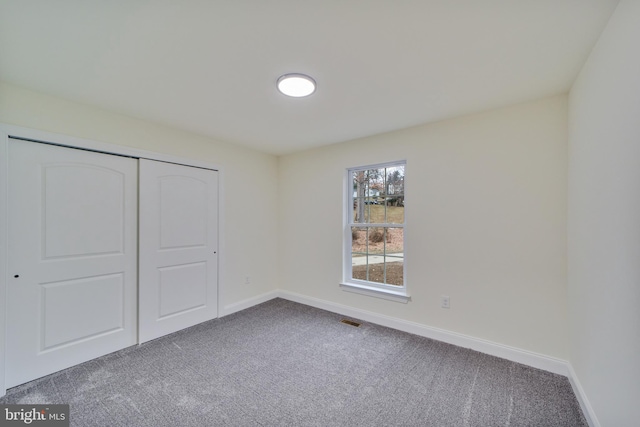 unfurnished bedroom with a closet and carpet flooring