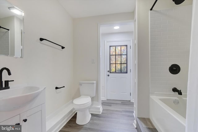 full bathroom featuring vanity, toilet, tiled shower / bath, and hardwood / wood-style floors