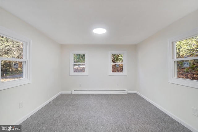 empty room with a baseboard heating unit, carpet flooring, and a wealth of natural light