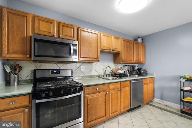 kitchen featuring sink, light tile patterned floors, stainless steel appliances, and tasteful backsplash