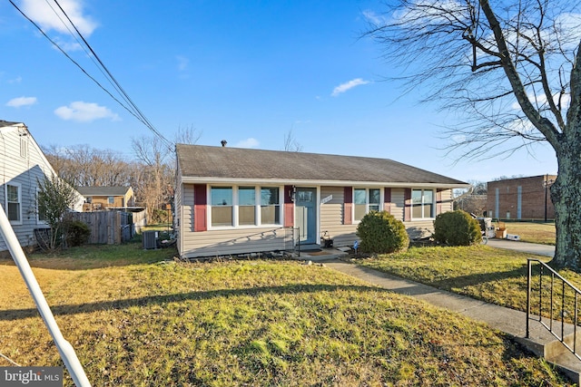 view of front of house with central AC and a front lawn