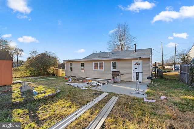 back of property with a lawn and a patio area