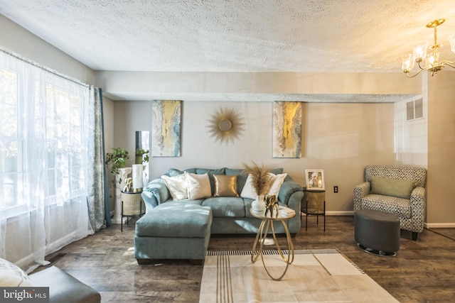 living room with an inviting chandelier, a textured ceiling, and hardwood / wood-style flooring