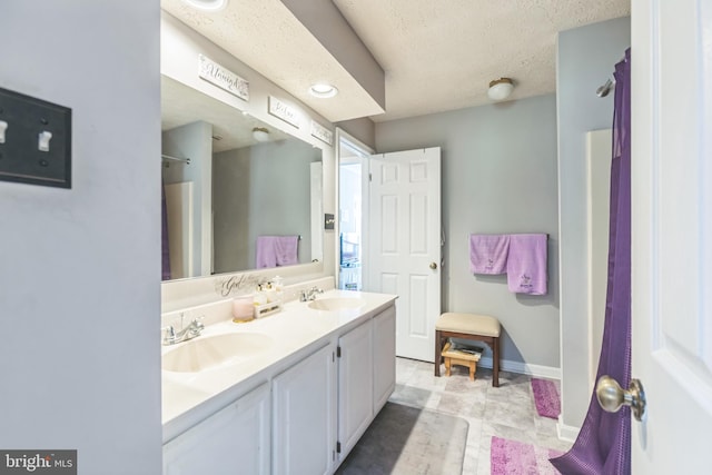 bathroom featuring vanity, a textured ceiling, and tile patterned flooring