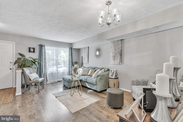 living room featuring hardwood / wood-style floors, a textured ceiling, and a chandelier