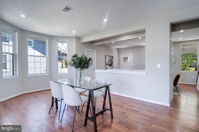 dining space with hardwood / wood-style floors and a healthy amount of sunlight