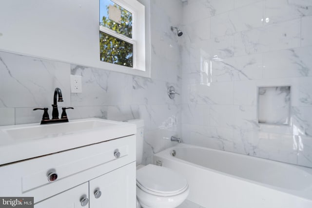 full bathroom with tiled shower / bath, vanity, toilet, and tile walls