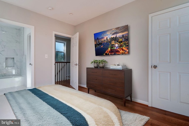 bedroom with connected bathroom and dark hardwood / wood-style flooring