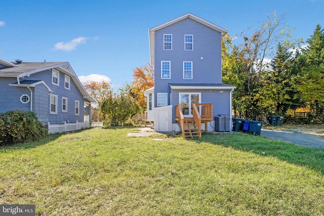 rear view of property with a yard, central AC, and a wooden deck