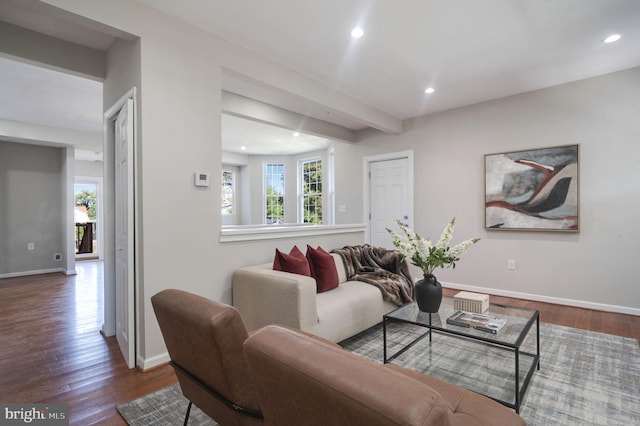 living room featuring beamed ceiling and dark wood-type flooring