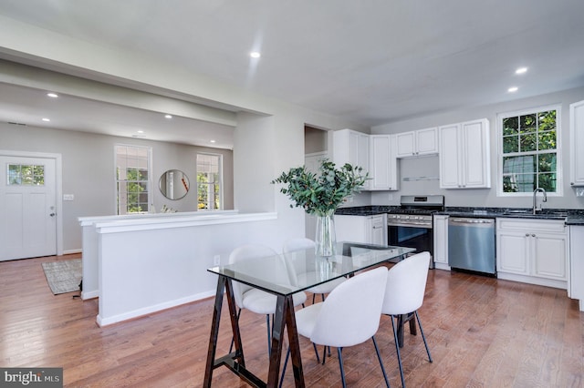 kitchen featuring sink, appliances with stainless steel finishes, light wood-type flooring, and white cabinets