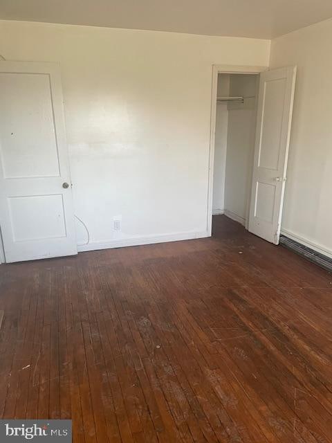 unfurnished bedroom featuring a closet and dark hardwood / wood-style flooring