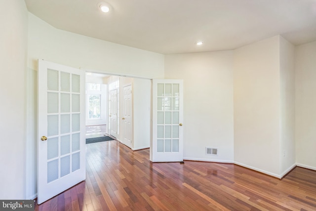 spare room with french doors and dark hardwood / wood-style flooring