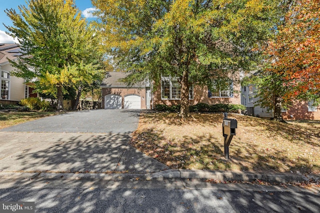 view of property hidden behind natural elements featuring a garage