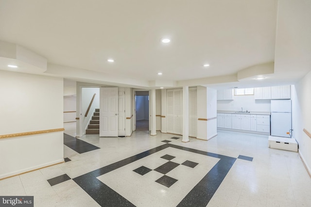 basement with white fridge and sink