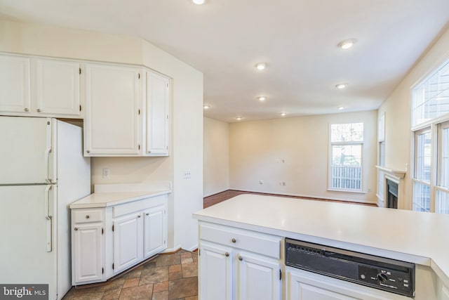 kitchen featuring white cabinets, white fridge, and dishwasher