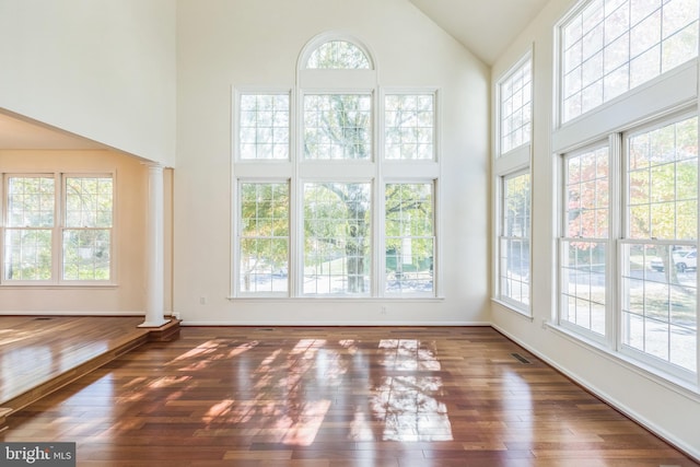 unfurnished sunroom featuring lofted ceiling and ornate columns