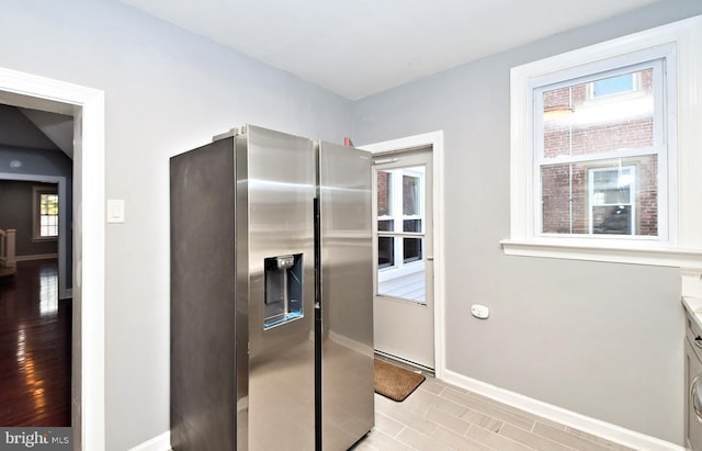 kitchen with stainless steel fridge, baseboards, and light countertops