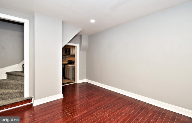 basement featuring wood finished floors, baseboards, stairway, and recessed lighting