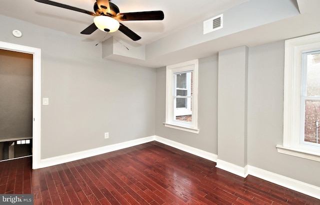 empty room with dark wood-style flooring, baseboards, and ceiling fan