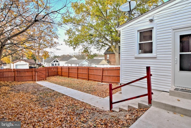 fenced backyard with a residential view and entry steps