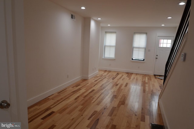 unfurnished room with visible vents, light wood-type flooring, recessed lighting, and baseboards